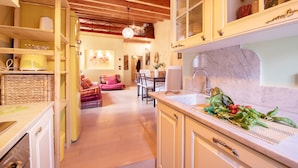 A kitchen with a marble countertop, wooden cabinets, and a sink. - Casa Milla In Center Town (Lucca)