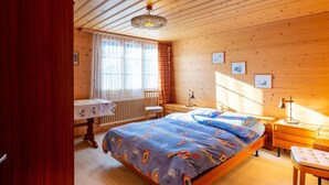 A wooden room with a bed, a desk, a chair, and a window. - Berna 2. Stock by Interhome (Lenk)