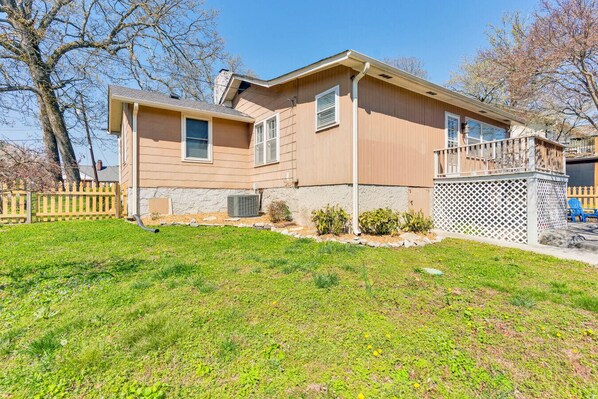 A two-story house with a front yard, a wooden fence, and a small garden area.