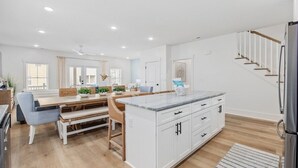 A modern kitchen with white cabinetry, a marble countertop, and a built-in island. - Luxury 5BR Escape | Pool & Hot Tub | Sleeps 16 (Surfside Beach)