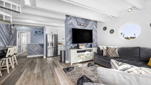 A modern living space with a kitchen, dining area, and a seating area with a view.