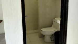 Une salle de bain avec des toilettes, une douche et un lavabo.
