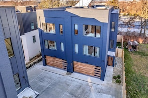 A modern multi-story building with large windows and a garage door.