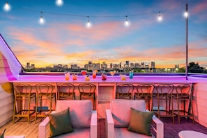 The rooftop bar keeps drinks flowing without anyone having to leave the group. Stools, cocktails, string lights, and the Nashville skyline as your backdrop - Game-day ready: Nashville-themed home, sleeps 12, game room near Geodis Park (Nashville)