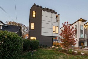 A modern two-story building with a flat roof, large windows, and a well-maintained garden. - Nashville getaway: 2 rooftop homes, sleeps 20, 6 bedrooms in the Gulch (Nashville)