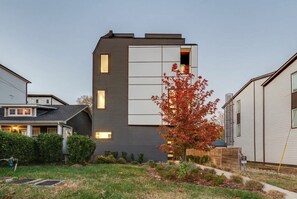 A modern two-story building with a flat roof and a large window on the second floor. - Nashville getaway: 2 rooftop homes, sleeps 20, 6 bedrooms in the Gulch (Nashville)