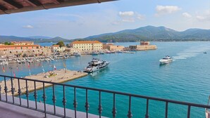 A marina with boats, a waterfront promenade, and historic buildings.