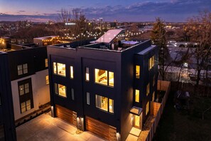 A modern multi-story building with multiple windows and a rooftop terrace.