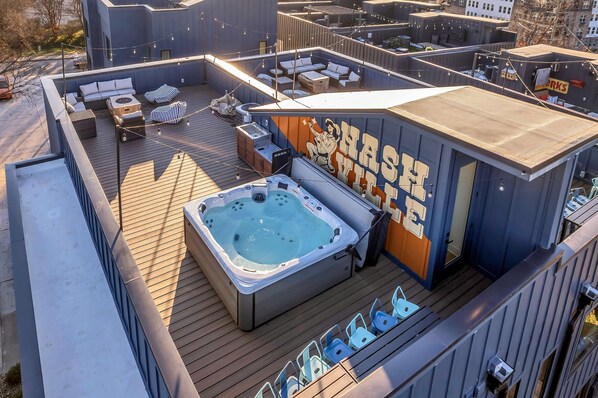 Une terrasse sur le toit dotée d’un jacuzzi, de coins salon et d’une fresque murale.