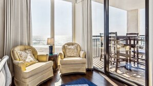 A room with two armchairs, a small table, and a view of the ocean through large windows. - Breathtaking Views - 7th Floor Beachfront Condo - Tennis, Basketball, Shuffleboard, Elevator, Pool (Navarre)