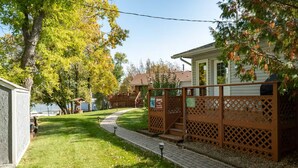 Propiedad residencial con un sendero pavimentado, cerca de madera y una casa con porche.