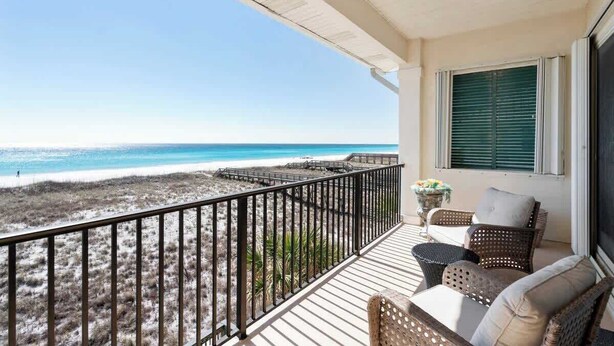 Ein Balkon mit Blick auf Strand und Meer.