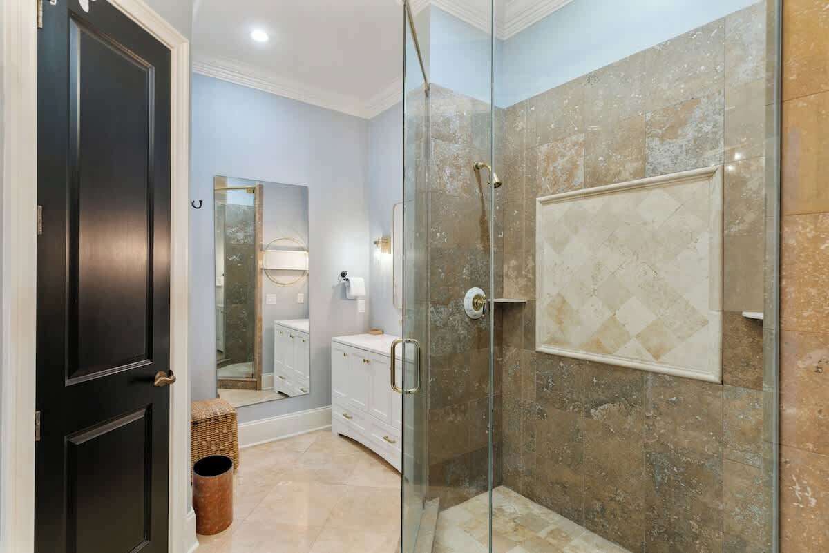 Une salle de bain moderne avec une douche à parois de verre, un meuble-lavabo blanc et un grand miroir.