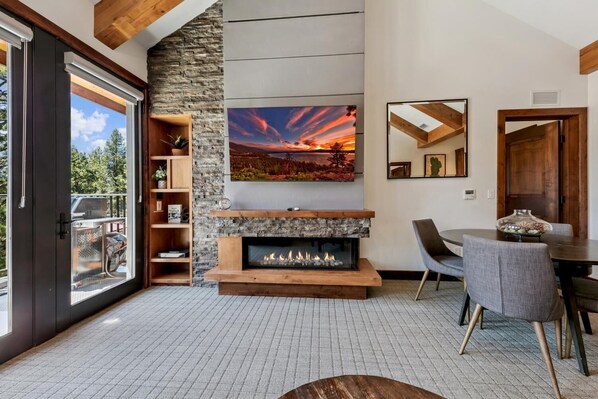 Una sala moderna con chimenea, un cuadro grande y una zona de comedor.