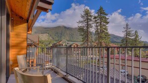A wooden balcony with chairs, a view of a mountain, and a parking area. - Luxury @Heavenly Village, with Pool+Hot Tub+Games (South Lake Tahoe)