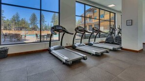 A gym with treadmills and exercise bikes, large windows with a view of trees and a building. - Luxury @Heavenly Village, with Pool+Hot Tub+Games (South Lake Tahoe)