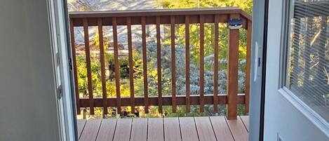 A wooden deck with a "WELCOME" mat and a "NO SMOKING" sign above a door.