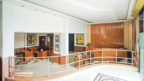 Un hall d’entrée spacieux, agrémenté d’un escalier en colimaçon, de meubles en bois et d’œuvres d’art aux murs.