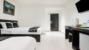 Une chambre d’hôtel avec un lit, un bureau, une télévision et une porte.
