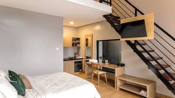Une chambre moderne avec un lit, un bureau et un escalier.