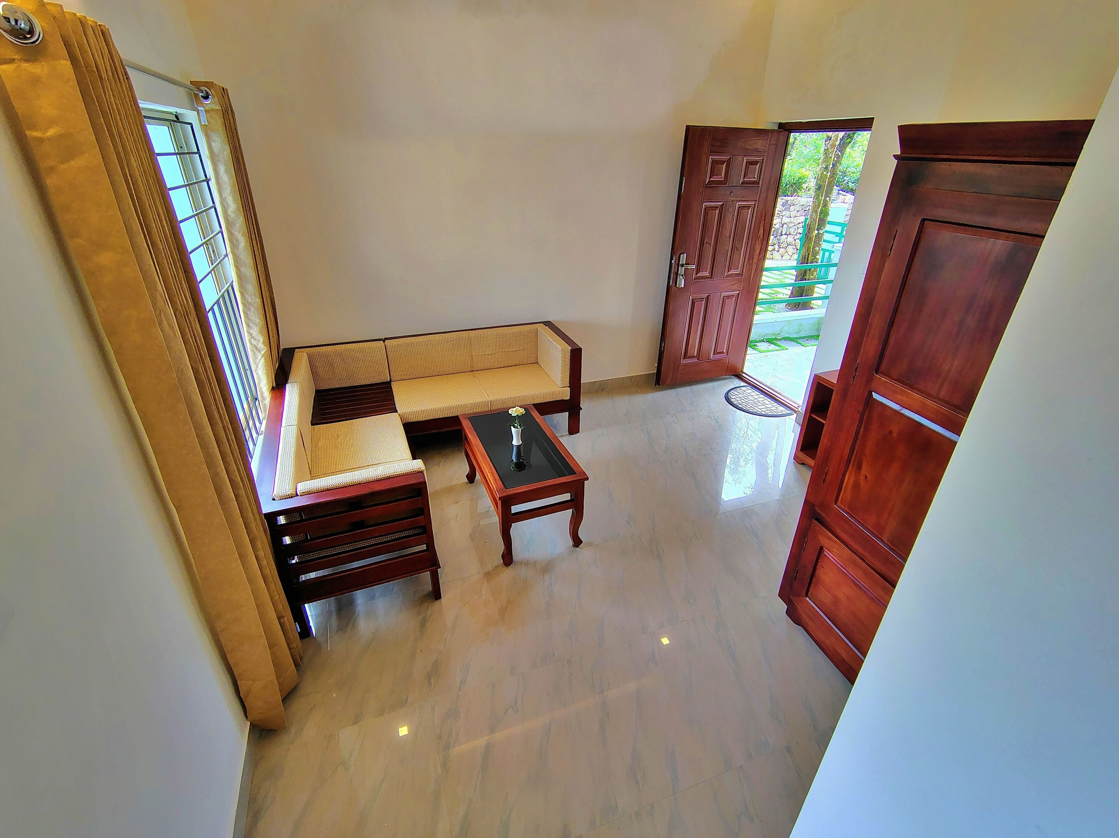 A room with a sofa, a coffee table, and a wooden door.