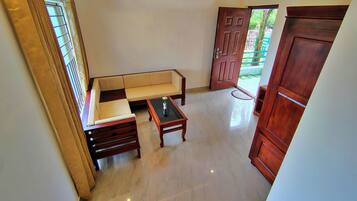 A room with a sofa, a coffee table, and a wooden door.