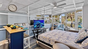 A modern room with a bed, TV, and a view of the outdoors.