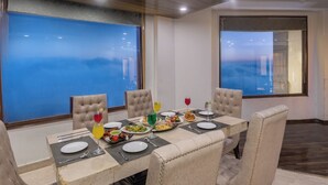 A dining area with a table set for four, featuring a variety of dishes and drinks. - The Solitaire Resort by Lawrence Hotels (Mussoorie)