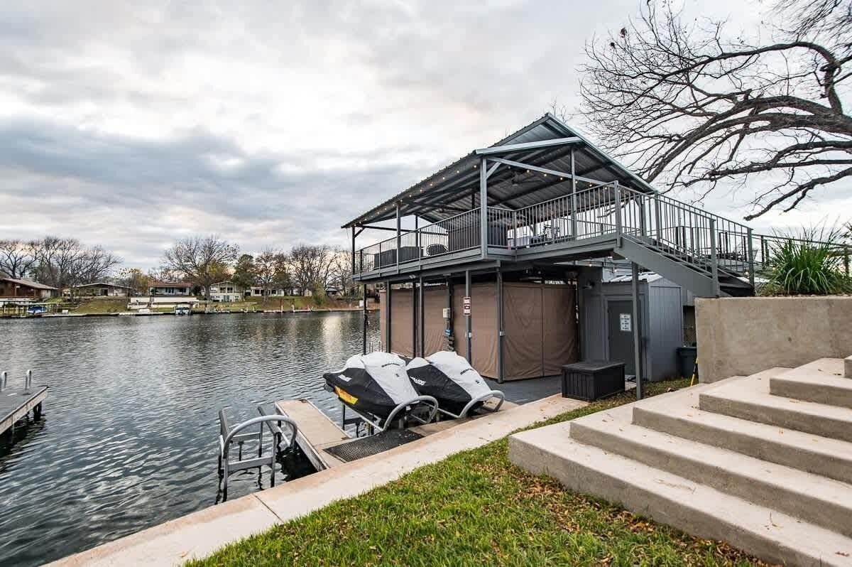 Un bâtiment situé au bord du lac, doté d’une terrasse couverte, d’une rampe d’accès pour bateaux et d’un quai.