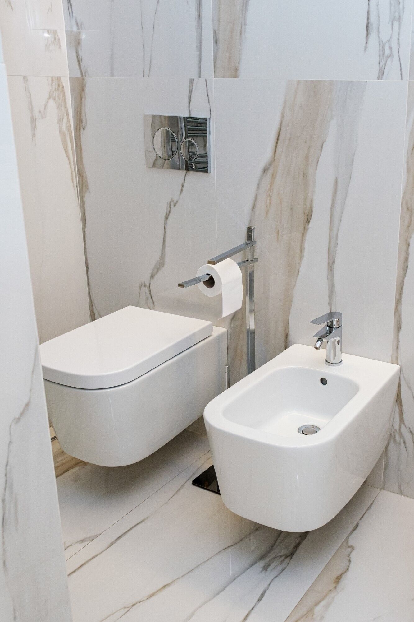 Un baño moderno con un bidé, un lavamanos y un inodoro.