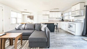 A modern kitchen with white cabinets, a stove, and a microwave. - #StayinMyDistrict Depot Bench Near Downtown BSU (Boise)