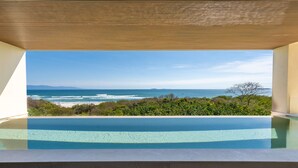 Ein Pool ohne Ende mit freiem Blick auf das Meer und den Strand.