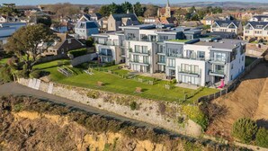 Un immeuble résidentiel moderne, doté de plusieurs étages, de grandes fenêtres et d’une pelouse bien entretenue.