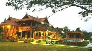 A traditional wooden building with a balcony and a small attached structure. - Baan mansin (Pak Chong)