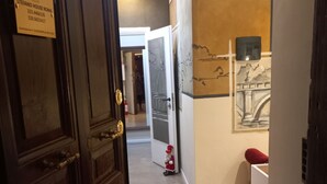 A hotel corridor with a wooden door, a sign indicating room number 333, and a wall-mounted light fixture. - Premium quadruple room Vatican  (Roma)