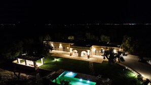 A large, well-lit building with a swimming pool, outdoor seating, and a paved courtyard. - Stunning luxury retreat with large pool. Great location near the sea in Puglia (Carovigno)
