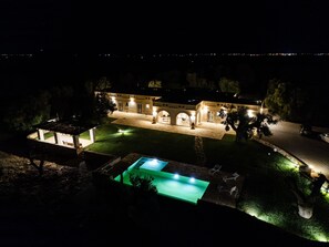 Ein großes, gut beleuchtetes Gebäude mit Pool, Außenbereich und gepflastertem Innenhof.