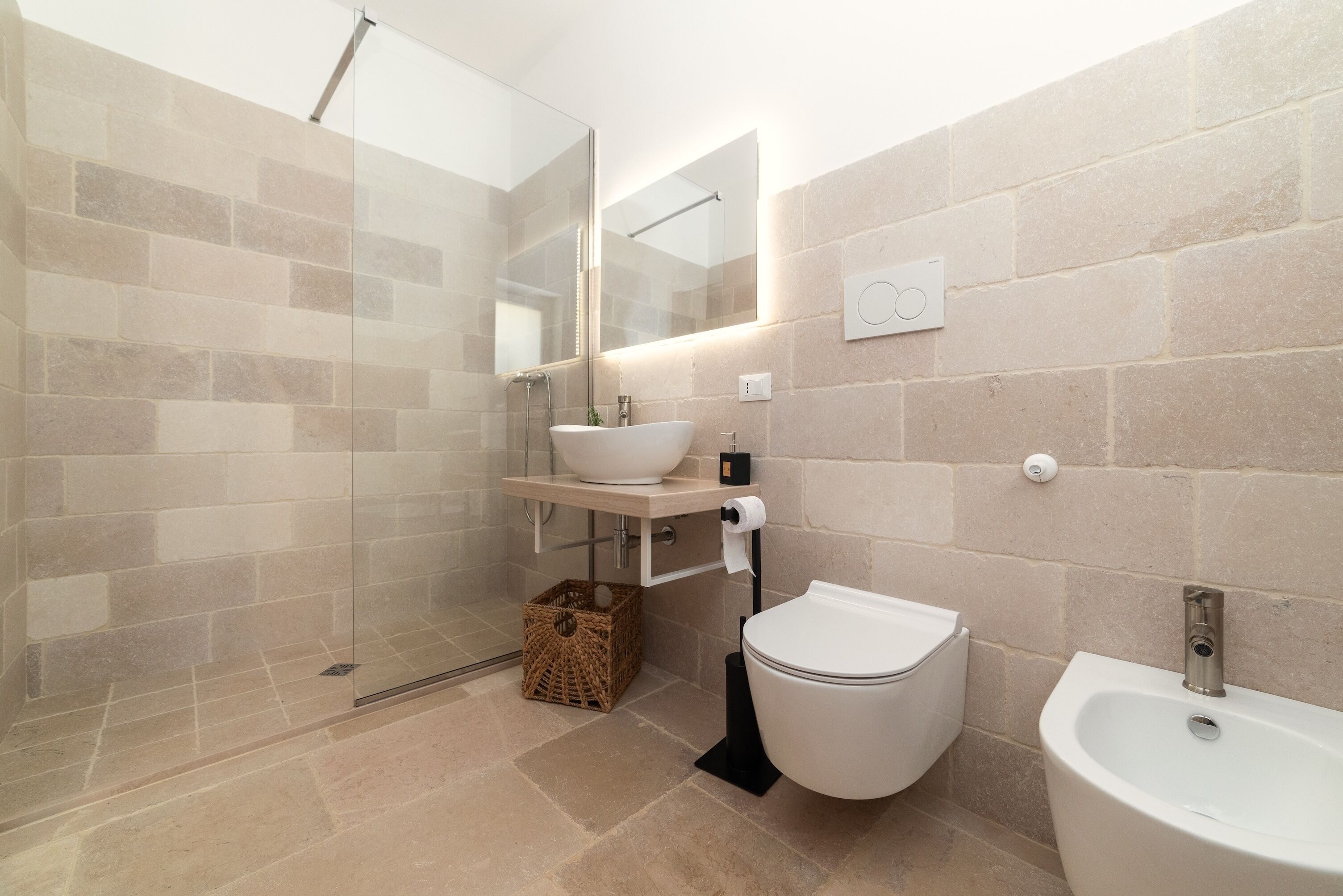 Ein modernes Badezimmer mit Duschkabine aus Glas, Waschbecken in Weiß und einem Bidet.