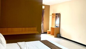 Habitación de hotel con una cama grande, un cabecero de madera, una mesita de noche, un espejo y una ventana con cortinas.