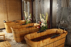 Wooden tubs with handles, arranged in a row, with a tiled wall and a bamboo blind in the background. - Majestic Mong Cai Hotel (Mong Cai)