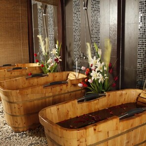 Un bagno con vasche in legno, uno specchio e una parete con decorazioni a mosaico.