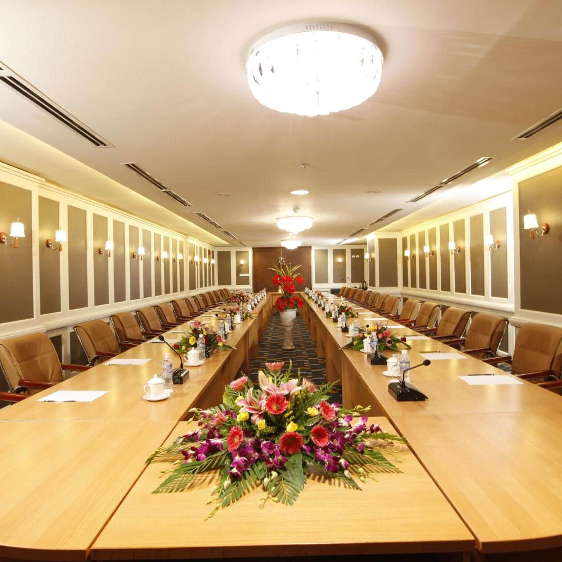 A conference room with a long table, chairs, and a chandelier.