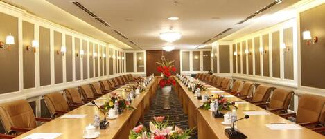 A conference room with a long table, chairs, and a chandelier.