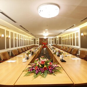 A conference room with a long table, chairs, and a chandelier. - Majestic Mong Cai Hotel (Mong Cai)