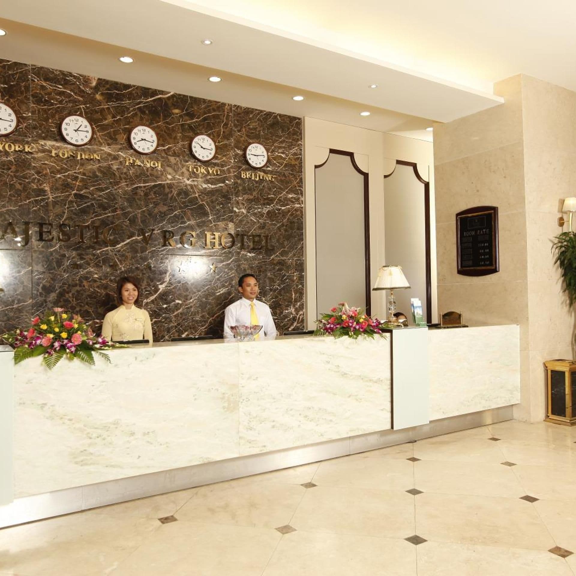 A hotel reception desk with clocks displaying times for New York, London, Paris, Tokyo, and Beijing.