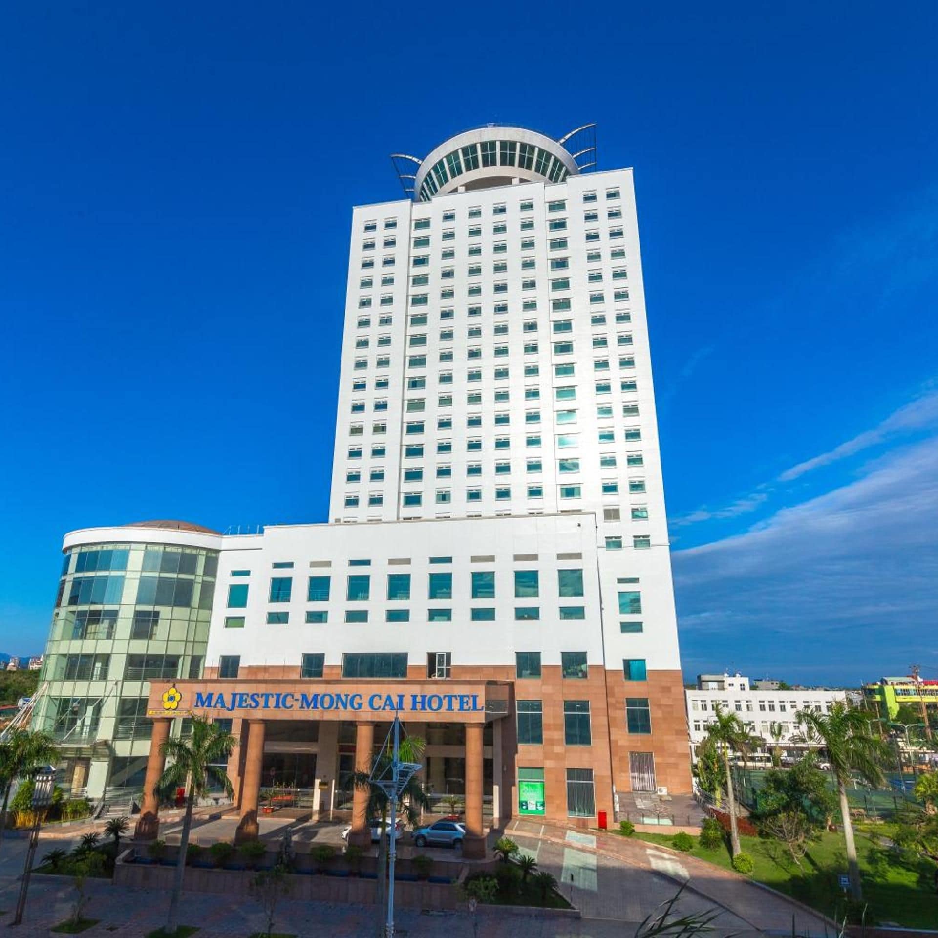 A multi-story hotel with a modern design, featuring a prominent curved glass facade and a flat roof.