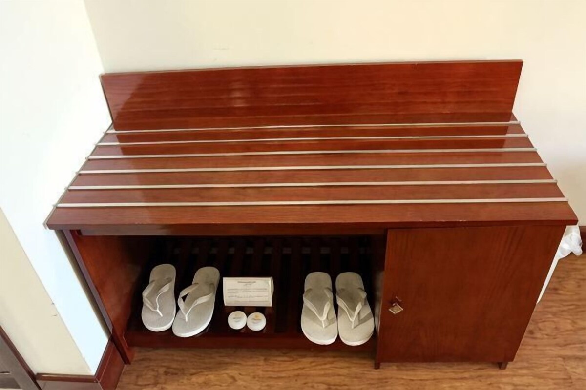 A wooden shoe rack with multiple pairs of shoes and a small display case.