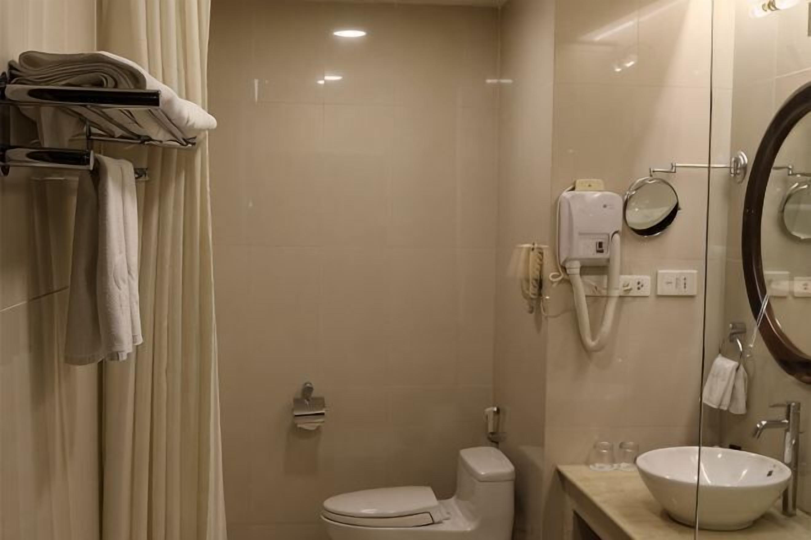 A bathroom with a toilet, sink, and shower.