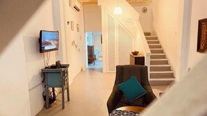 A modern living room with a sofa and a television on a stand. - Georgetown Kyash House 23 (Northeast Penang Island)