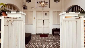 A hallway with a patterned floor, a white door, and a sign above the door. - Georgetown Kyash House 23 (Northeast Penang Island)
